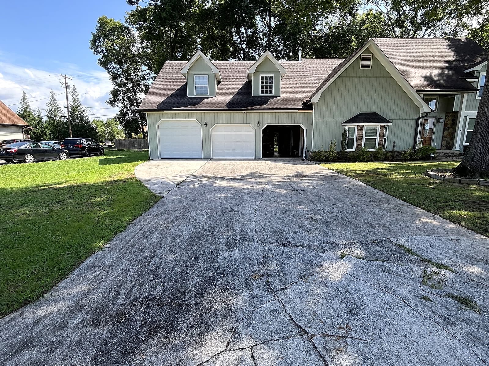 Cracked, grimy three-car driveway before pressure washing