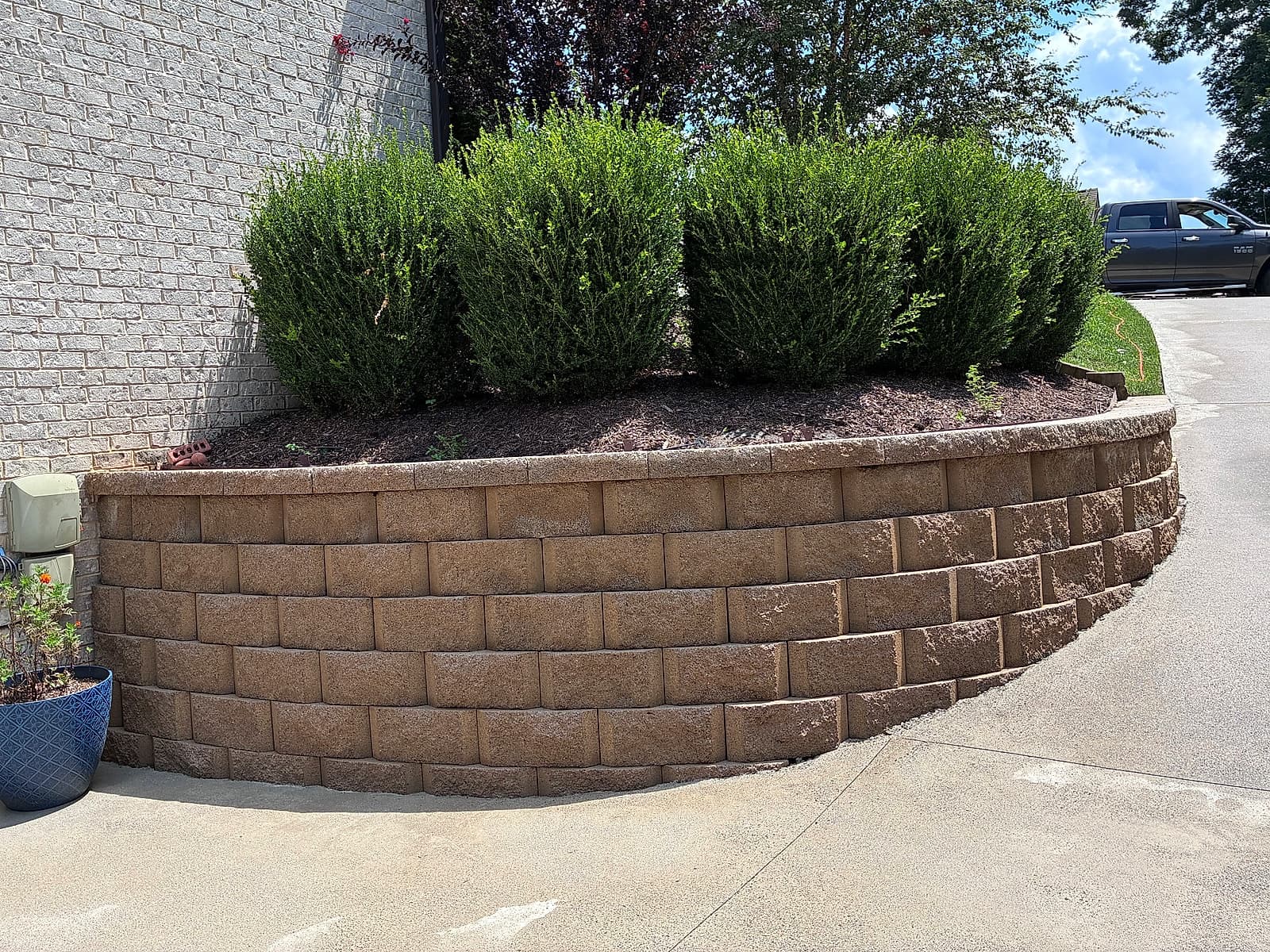 Clean, warm-toned curved retaining wall after pressure washing
